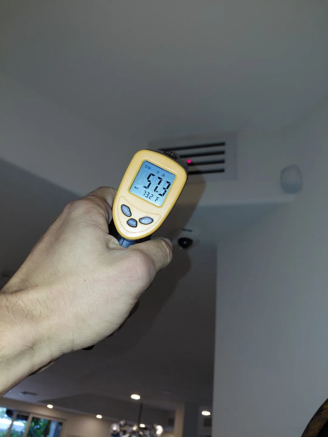 Thermometer reading 57.3 degrees at a supply vent after air duct cleaning in Aventura, FL