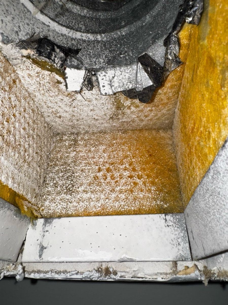 Duct interior with brown and orange buildup before coating