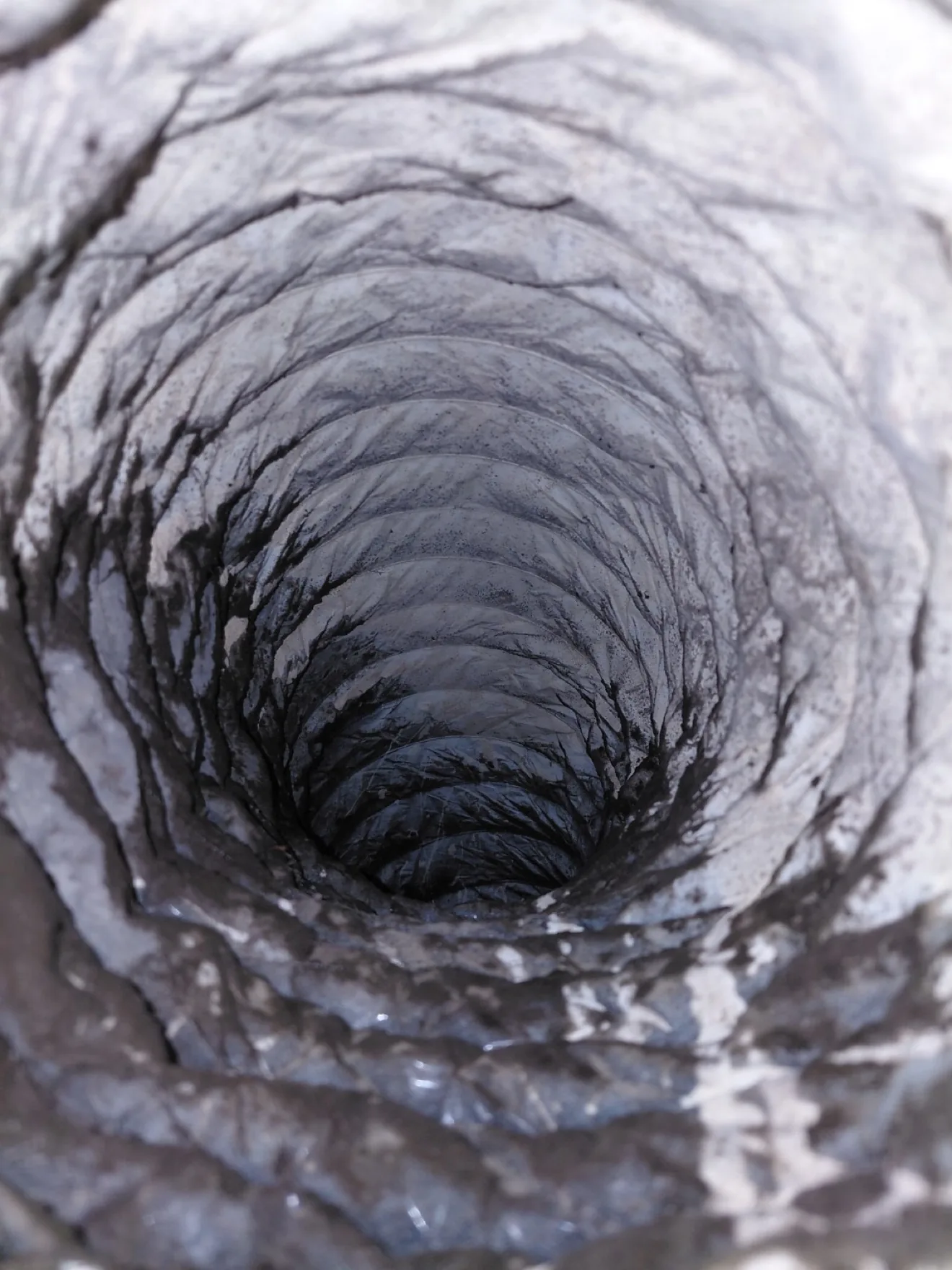 Inside a dirty air duct before cleaning, showing dust and debris buildup