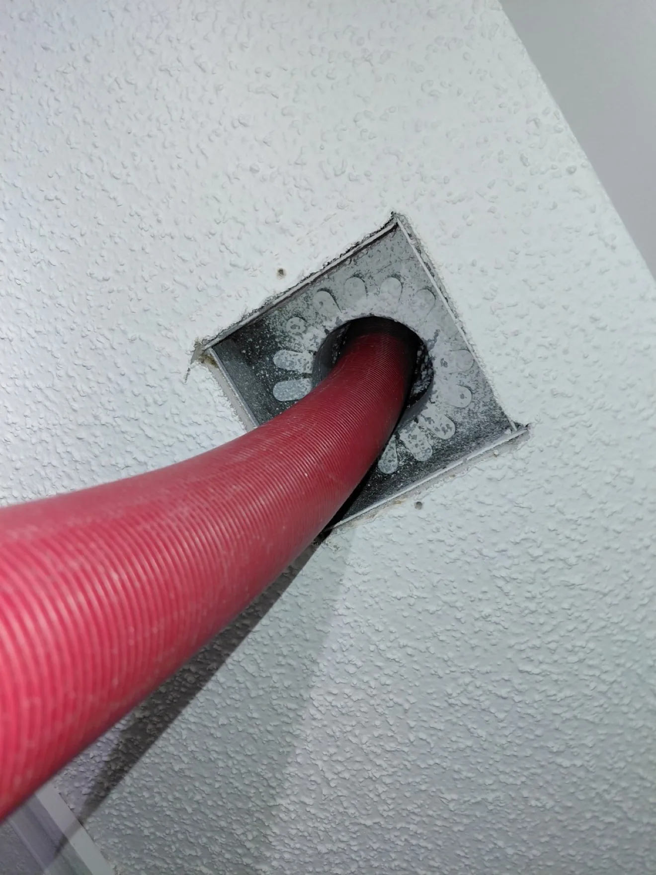 Cleaning hose inserted into a ceiling air register